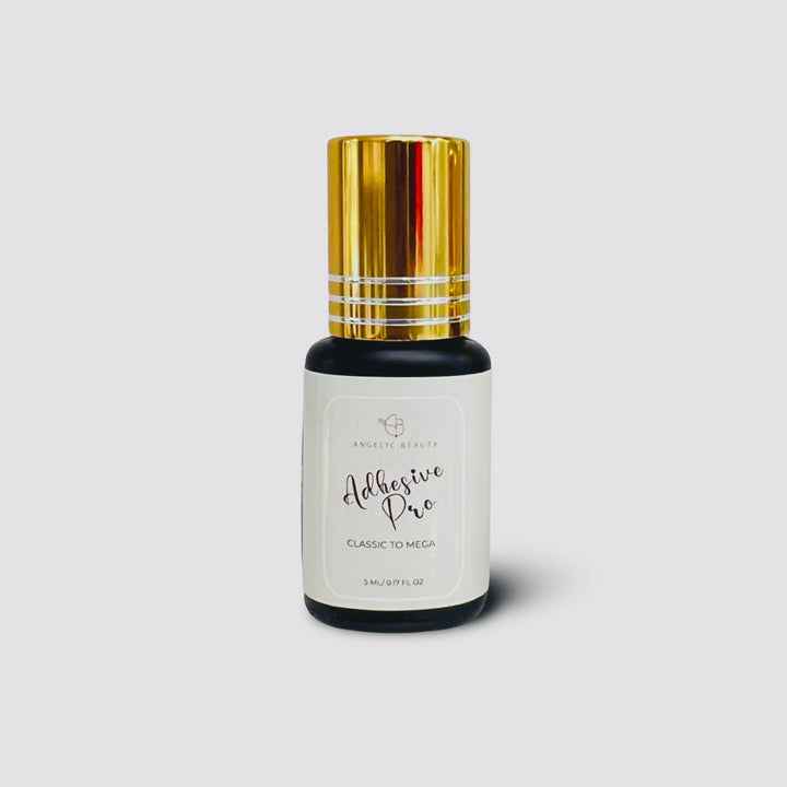 Bottle of adhesive pro with gold cap on a light gray background